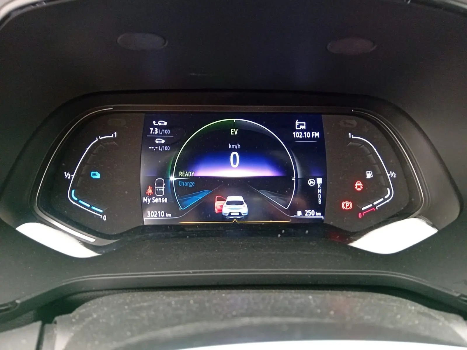 Tableau de bord numérique du Renault Captur E-Tech gris alu/noir, affichant la vitesse à 0 km/h et l'autonomie.
