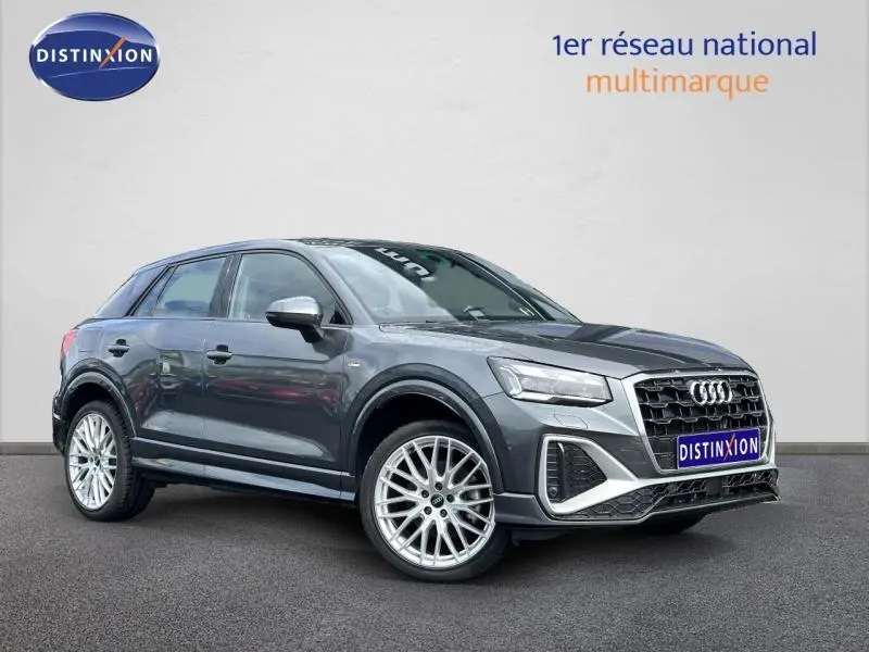 Audi Q2 30 TDI S line gris Daytona nacré en 3/4 avant droit avec jantes alliage et calandre noire distinctive.