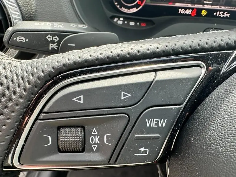 Gros plan sur les commandes multifonctions du volant cuir perforé de l'Audi Q2 30 TDI S line 2024.