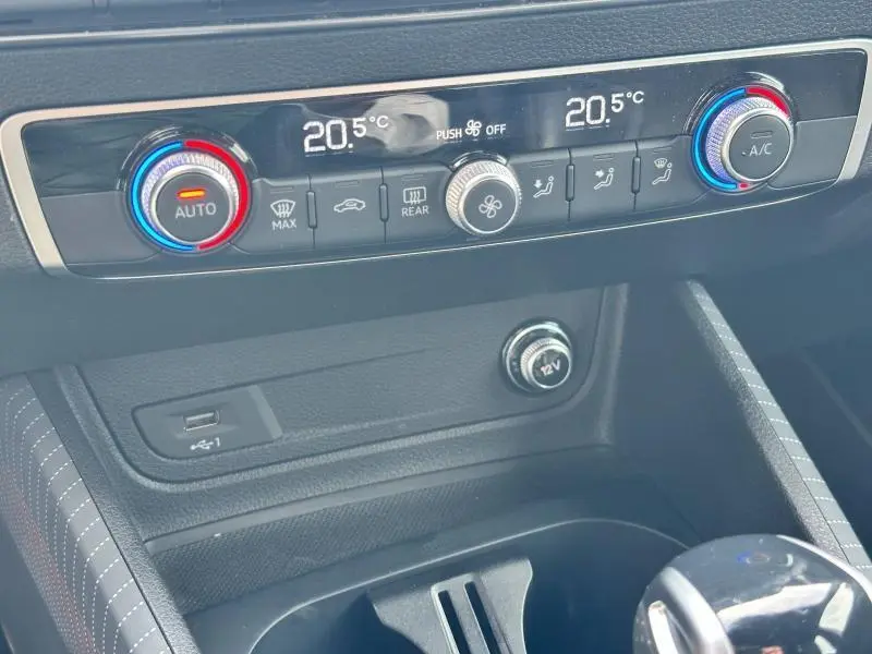 Gros plan sur la console centrale de l'Audi Q2 30 TDI 2024, montrant la climatisation automatique et les commandes de température.