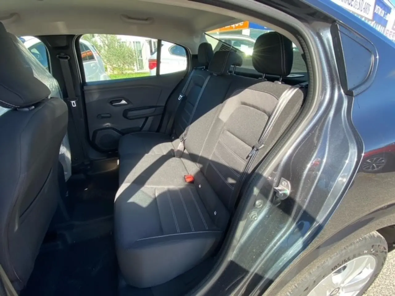 Vue intérieure arrière côté droit d'une Dacia Logan gris 2022, sièges arrière en tissu noir avec ceinture de sécurité.