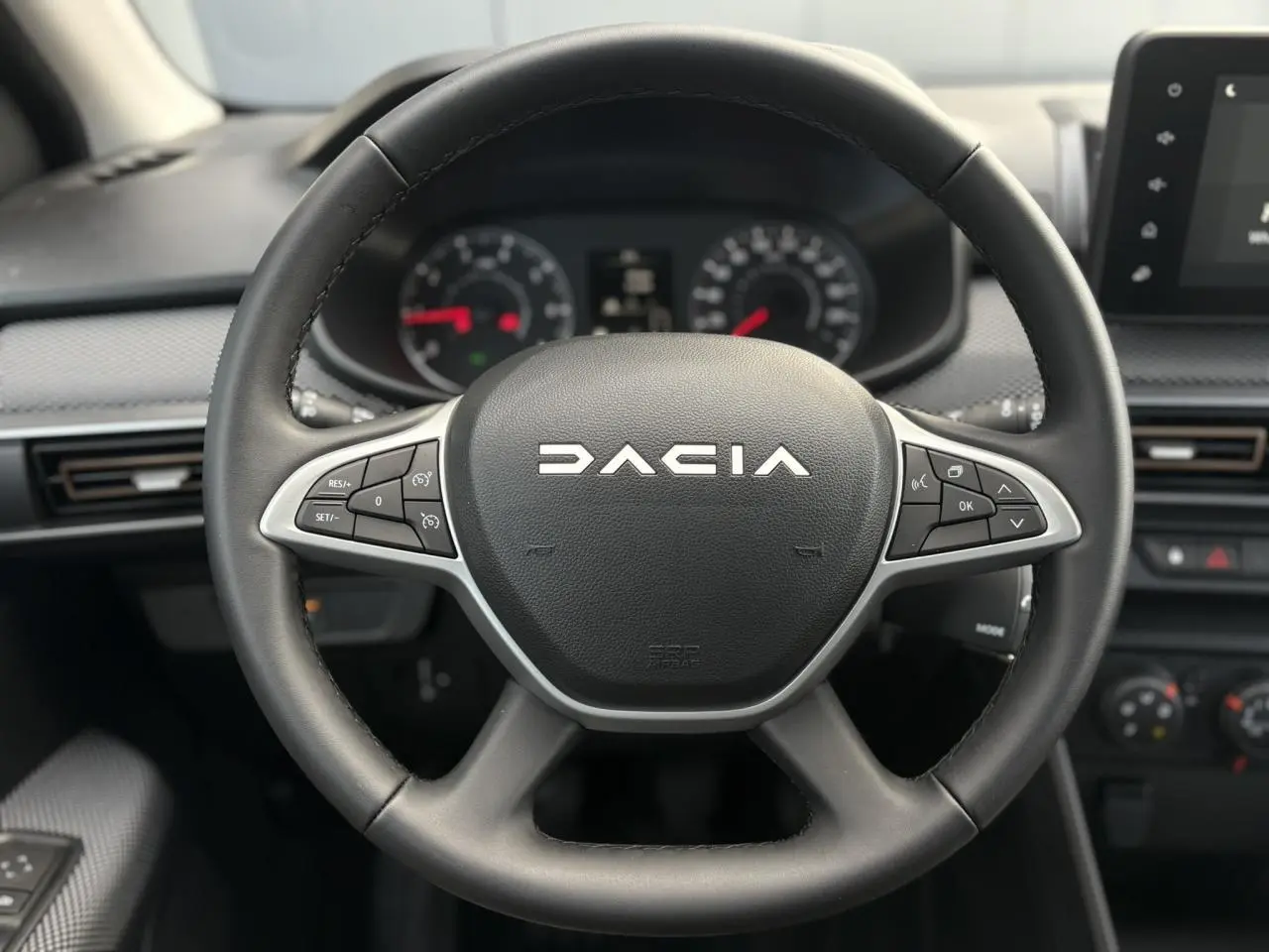Volant noir avec logo Dacia au centre, vue frontale du poste de conduite de la Sandero Stepway 2025.