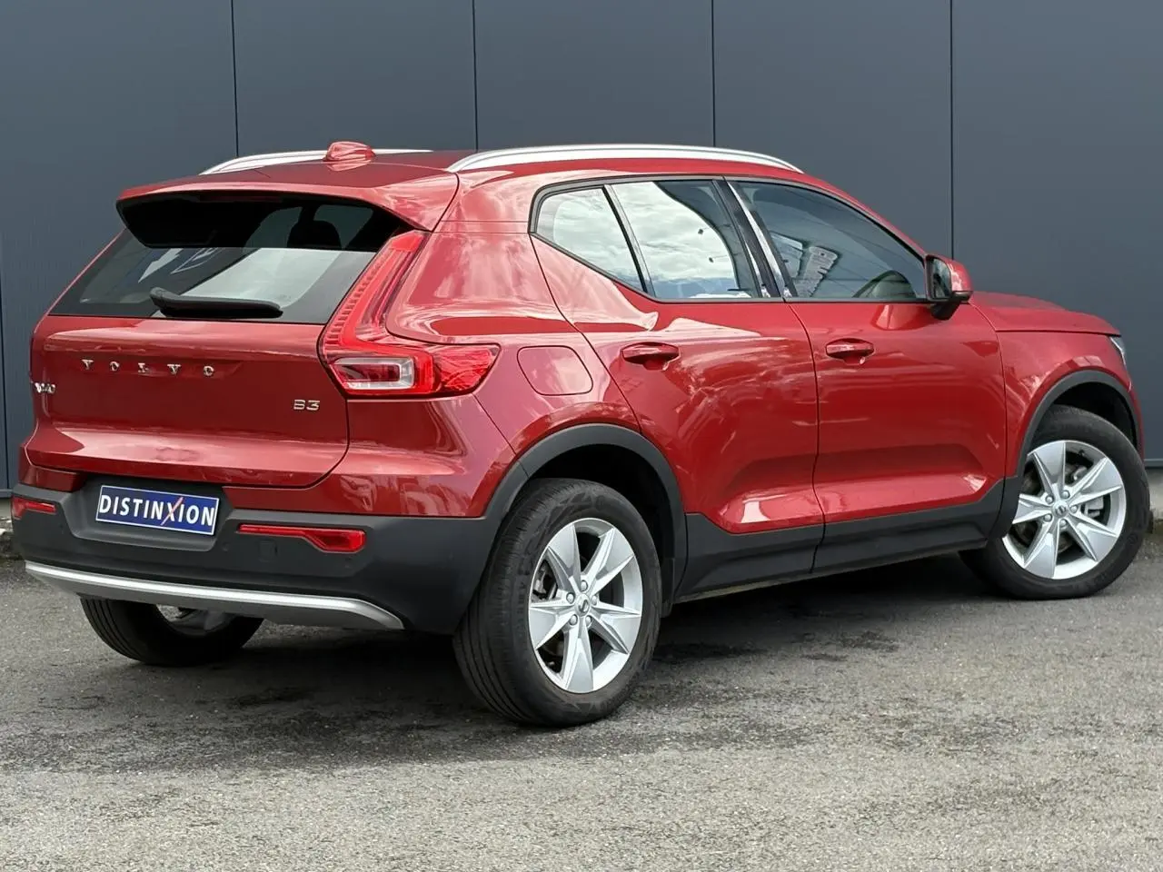 Volvo XC40 B3 MHEV rouge Fusion vue 3/4 arrière droit, avec jantes alliage 18 pouces et toit blanc.