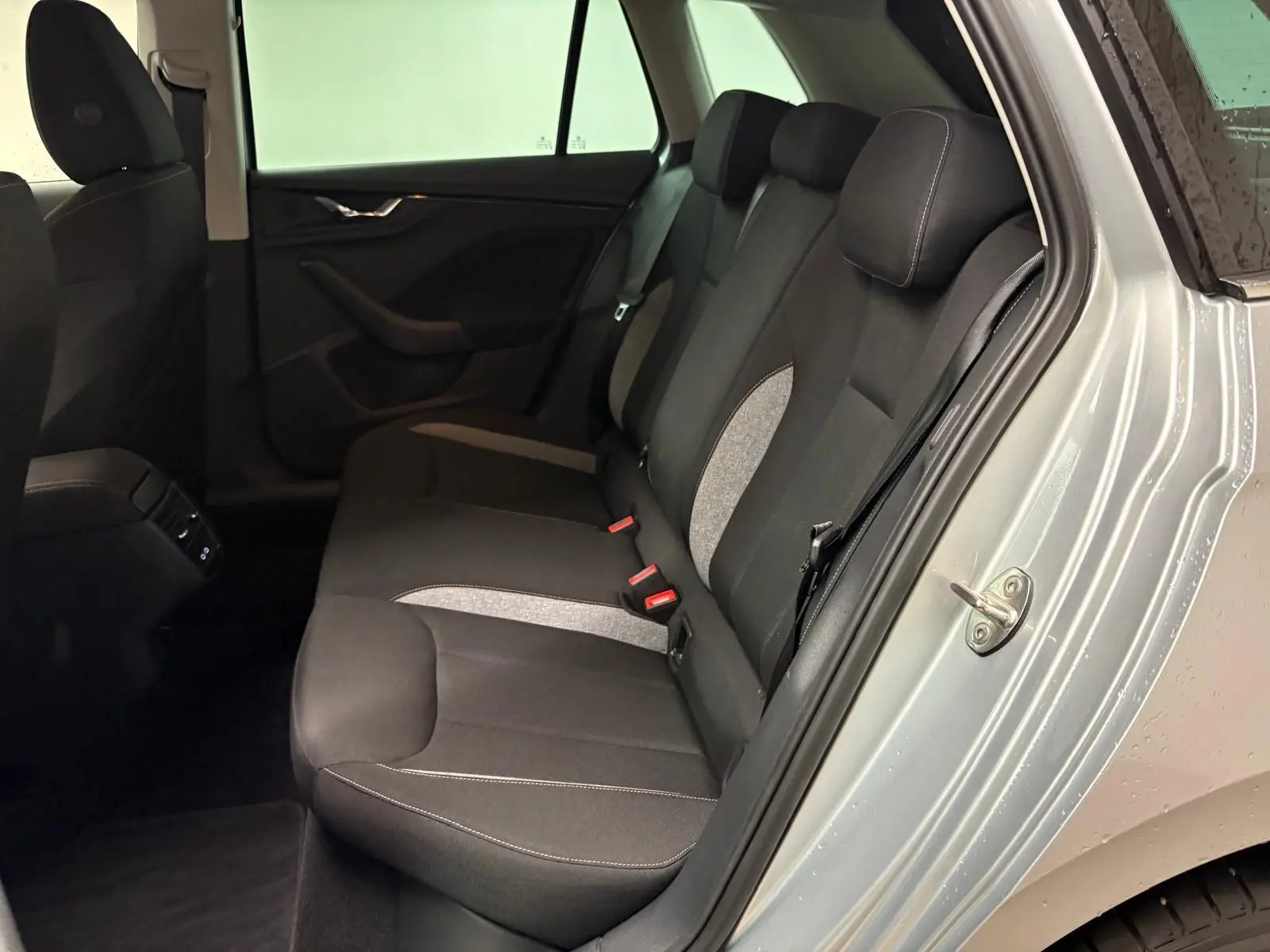 Vue intérieure côté droit sur la banquette arrière noire avec inserts gris du Skoda Kamiq gris argent 2025.