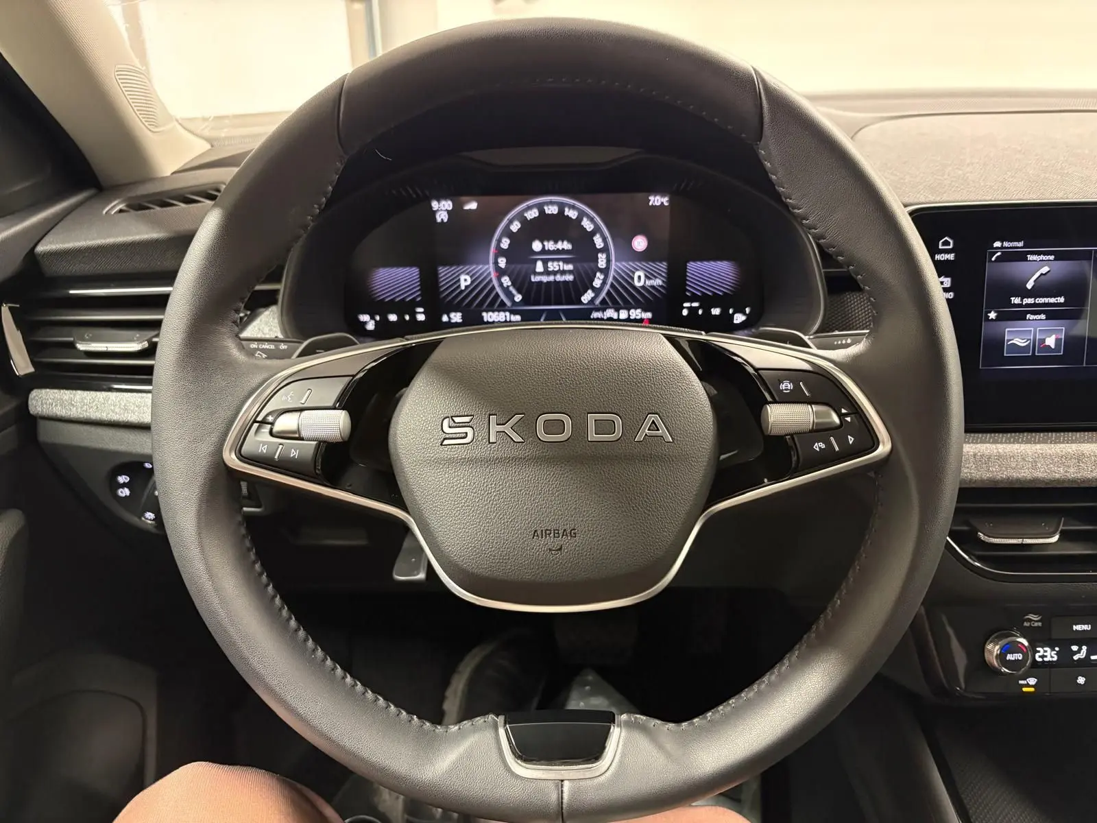 Vue intérieure centrée sur le volant SKODA du KAMIQ 2025 avec tableau de bord numérique et commandes intégrées.