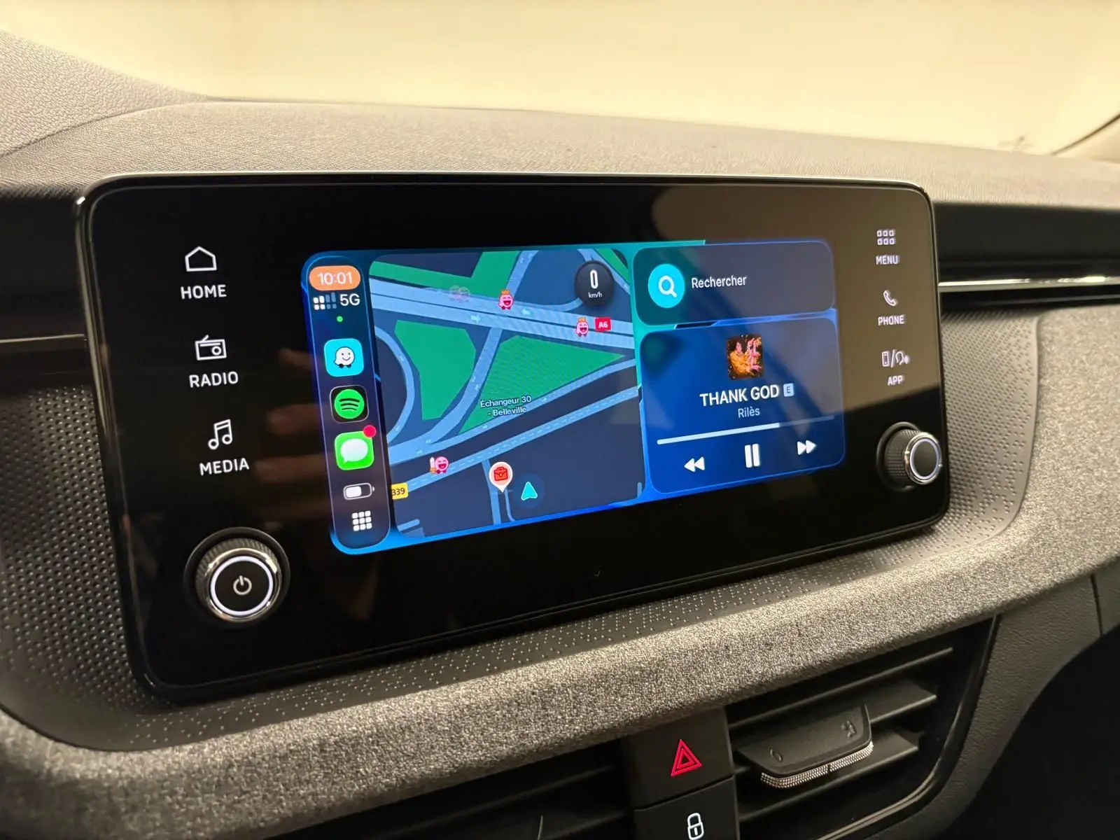 Écran tactile central du Skoda Kamiq 2025 affichant navigation et musique, avec commandes tactiles et bouton rotatif.