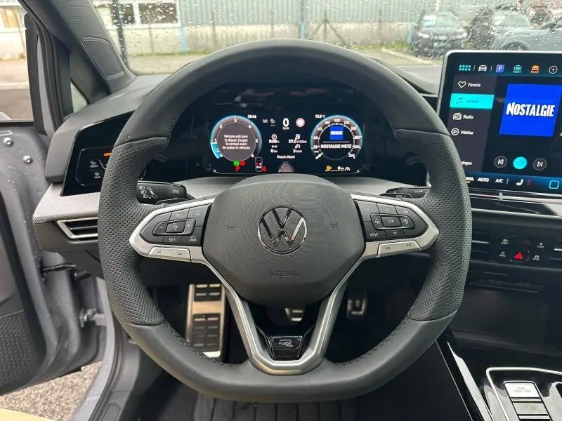 Vue intérieure centrée sur le volant noir perforé de la Volkswagen Golf 2.0 TDI R-Line 2026 avec tableau de bord numérique allumé.