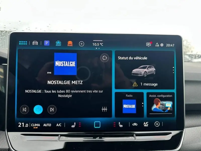 Vue rapprochée de l’écran tactile intérieur du Volkswagen Golf gris 2.0 TDI R-Line 2026 affichant la radio et le statut du véhicule.