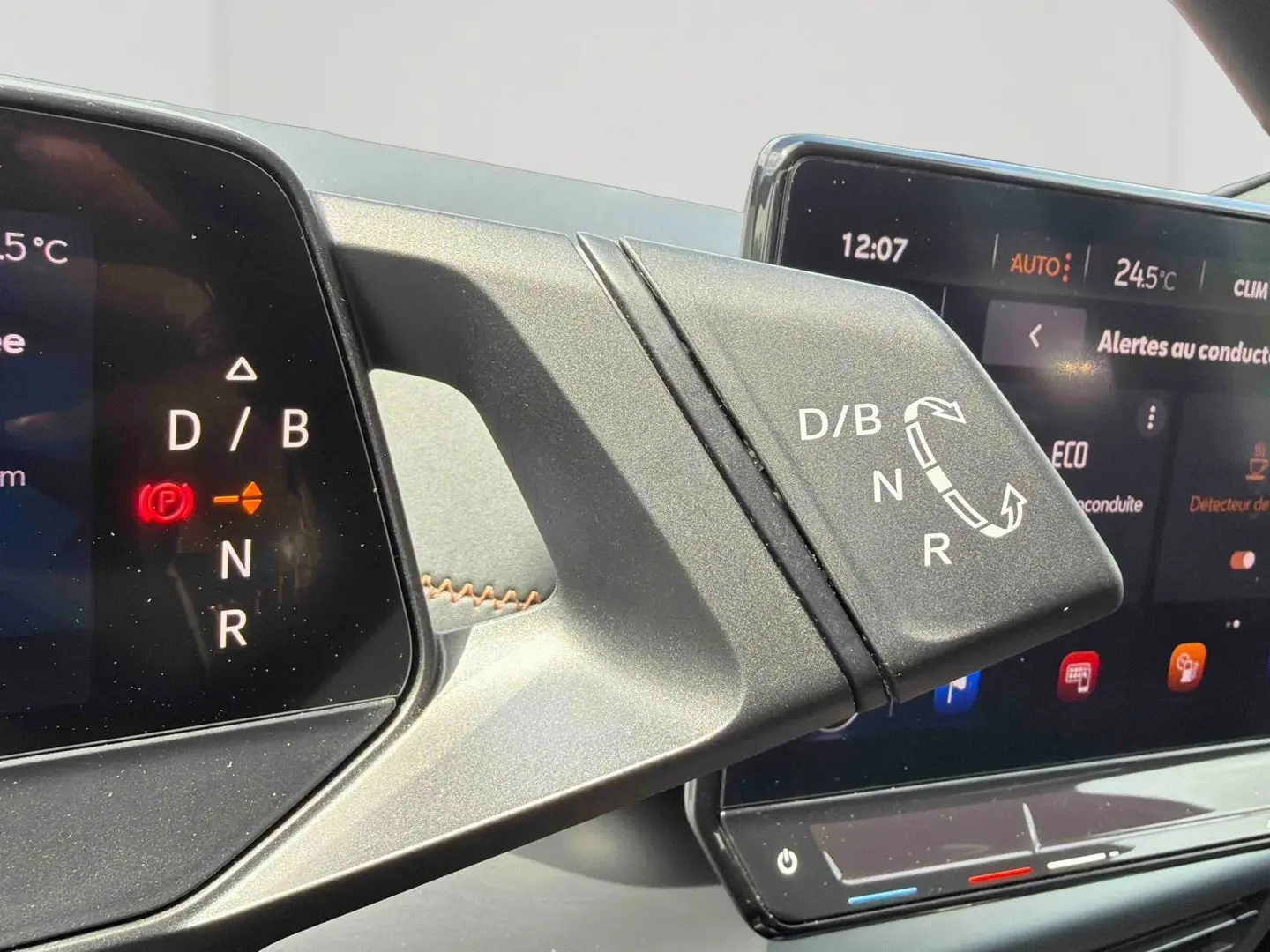 Détail du levier de vitesses électrique avec affichage digital, intérieur moderne du CUPRA Born blanc 2024.
