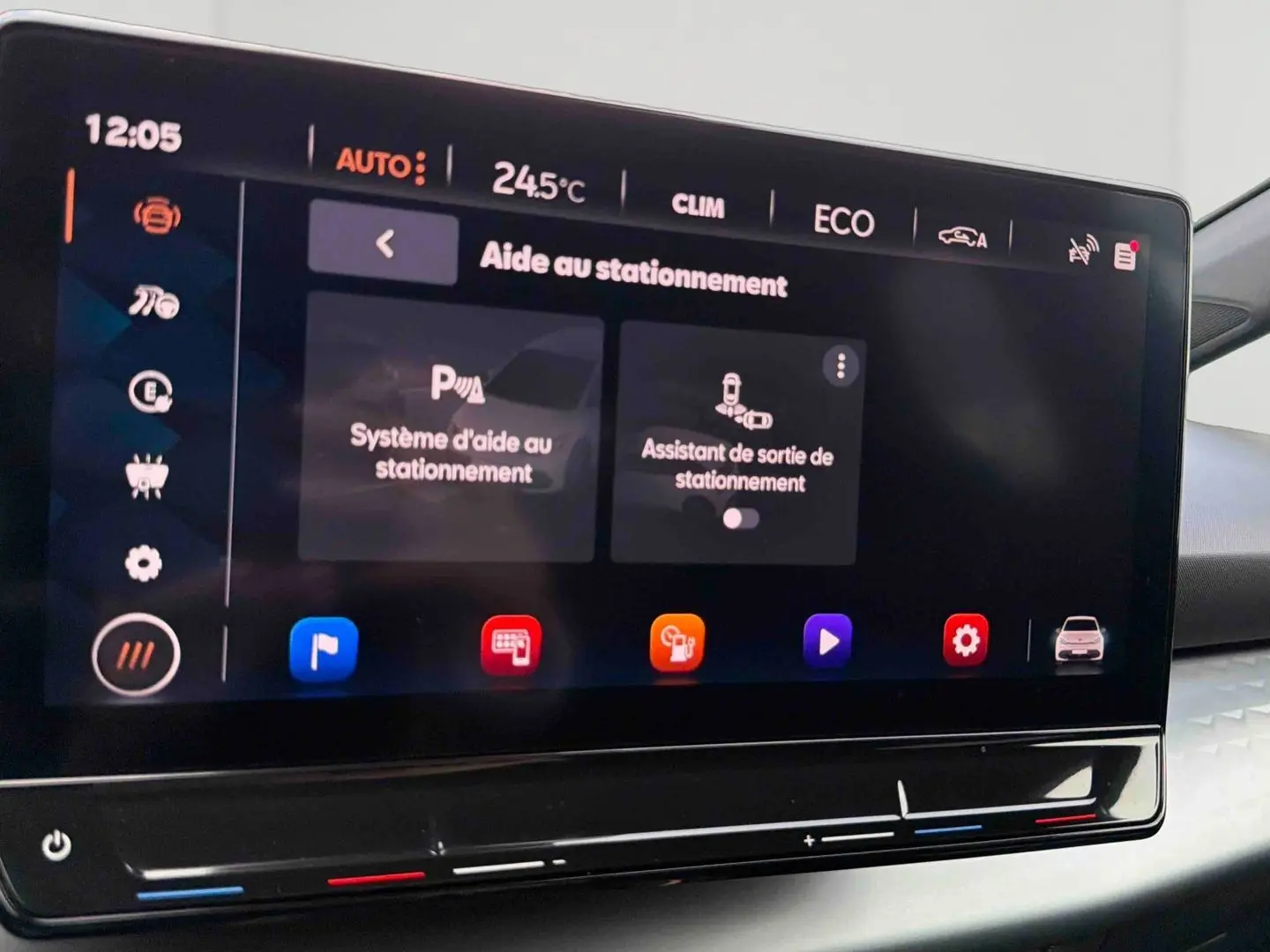 Écran tactile intérieur du CUPRA Born 2024 montrant l'aide au stationnement avec interface moderne et commandes climatiques intégrées.