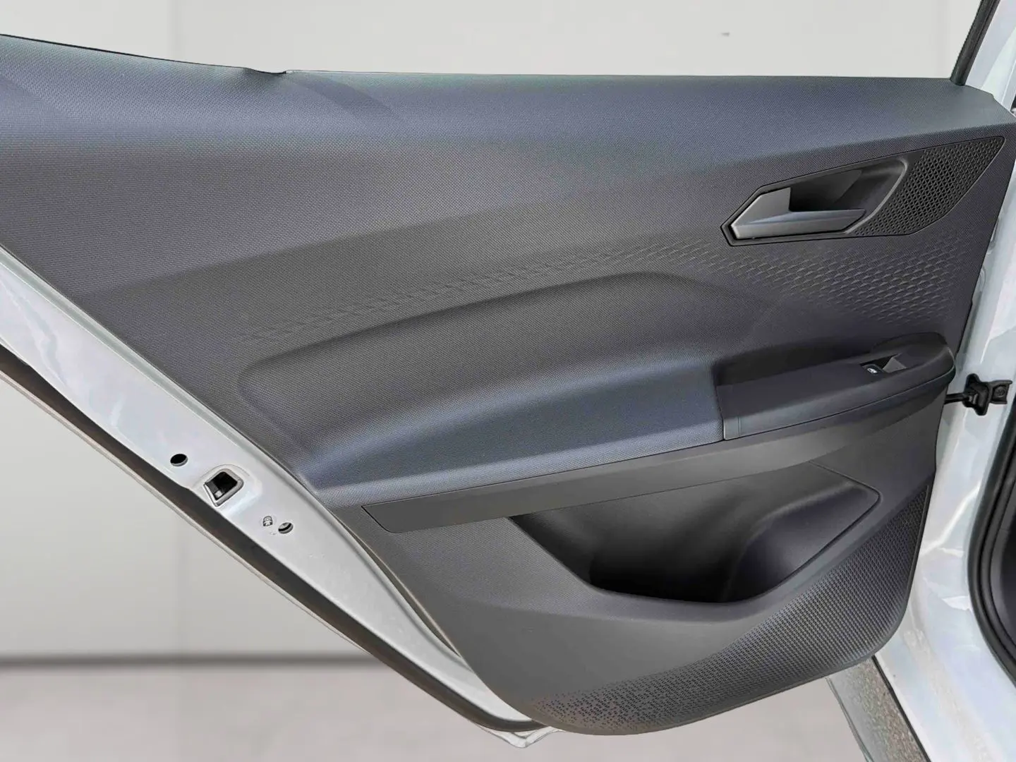 Gros plan sur la porte avant gauche blanche de la CUPRA Born 2024, montrant la garniture intérieure noire texturée.