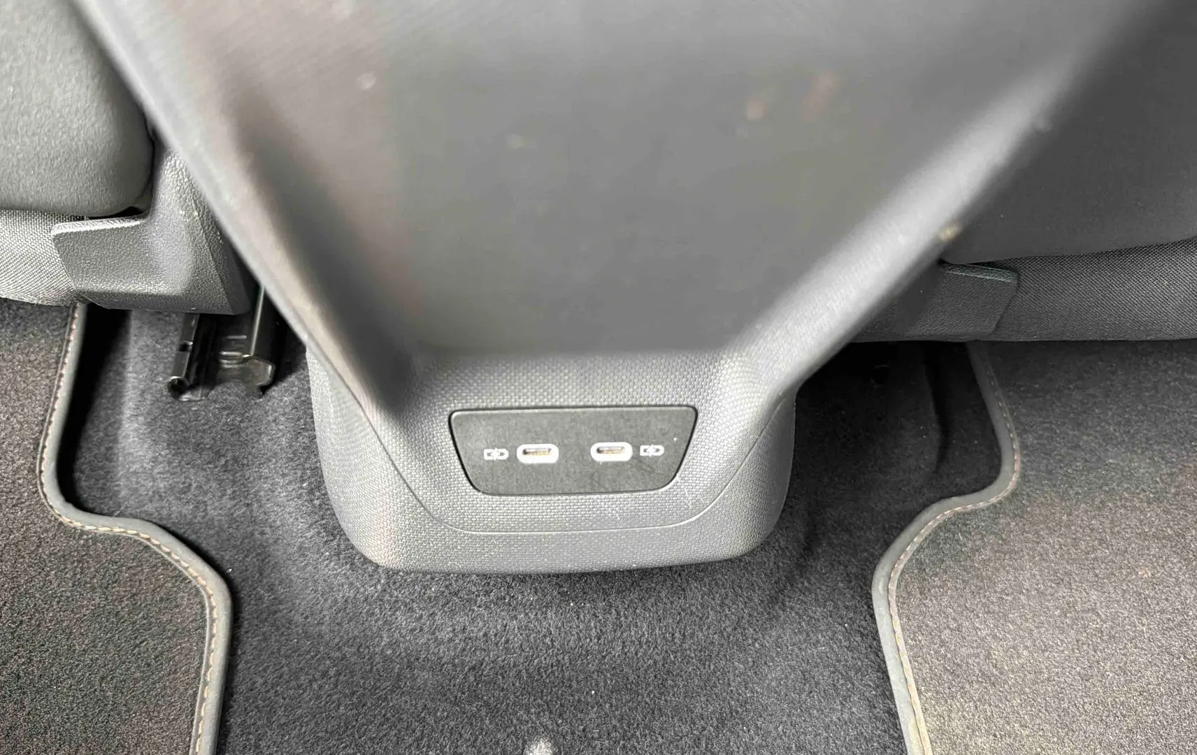 Vue rapprochée des ports USB-C situés à l'arrière de la console centrale du CUPRA Born blanc 2024.