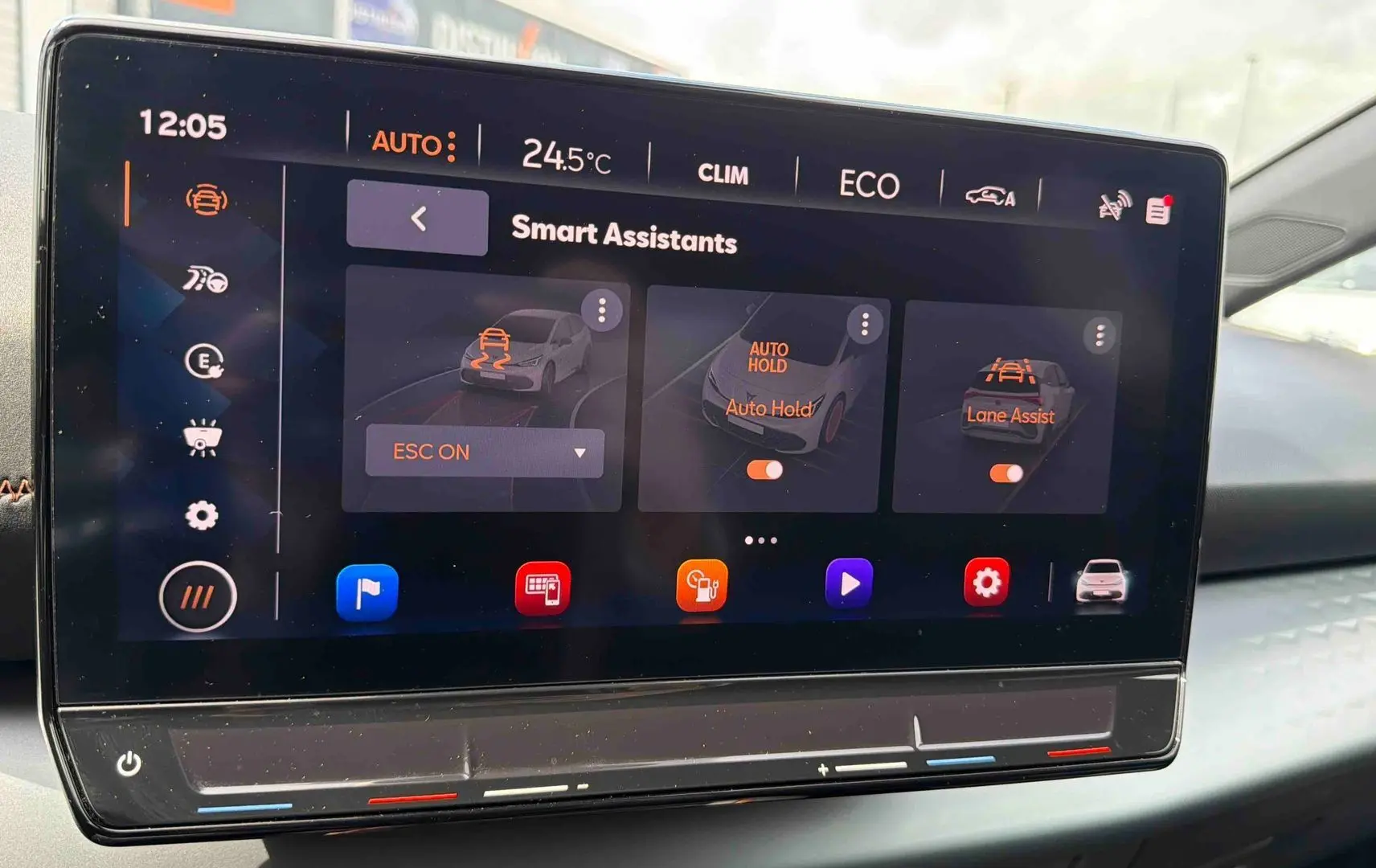 Écran tactile central du CUPRA Born 2024 montrant les assistants intelligents avec interface moderne et détails en orange.