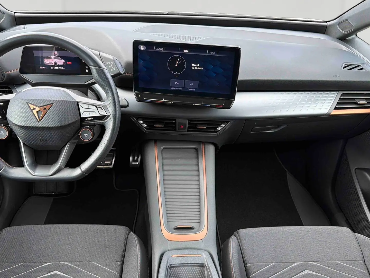 Vue intérieure avant du tableau de bord gris clair et volant multifonction noir avec logo CUPRA en cuivre du Born e-boost 2024.