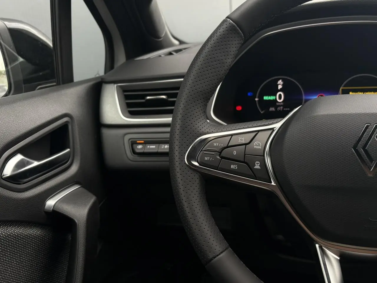 Gros plan sur le volant noir perforé et le tableau de bord numérique du Renault Captur 2026, côté conducteur.