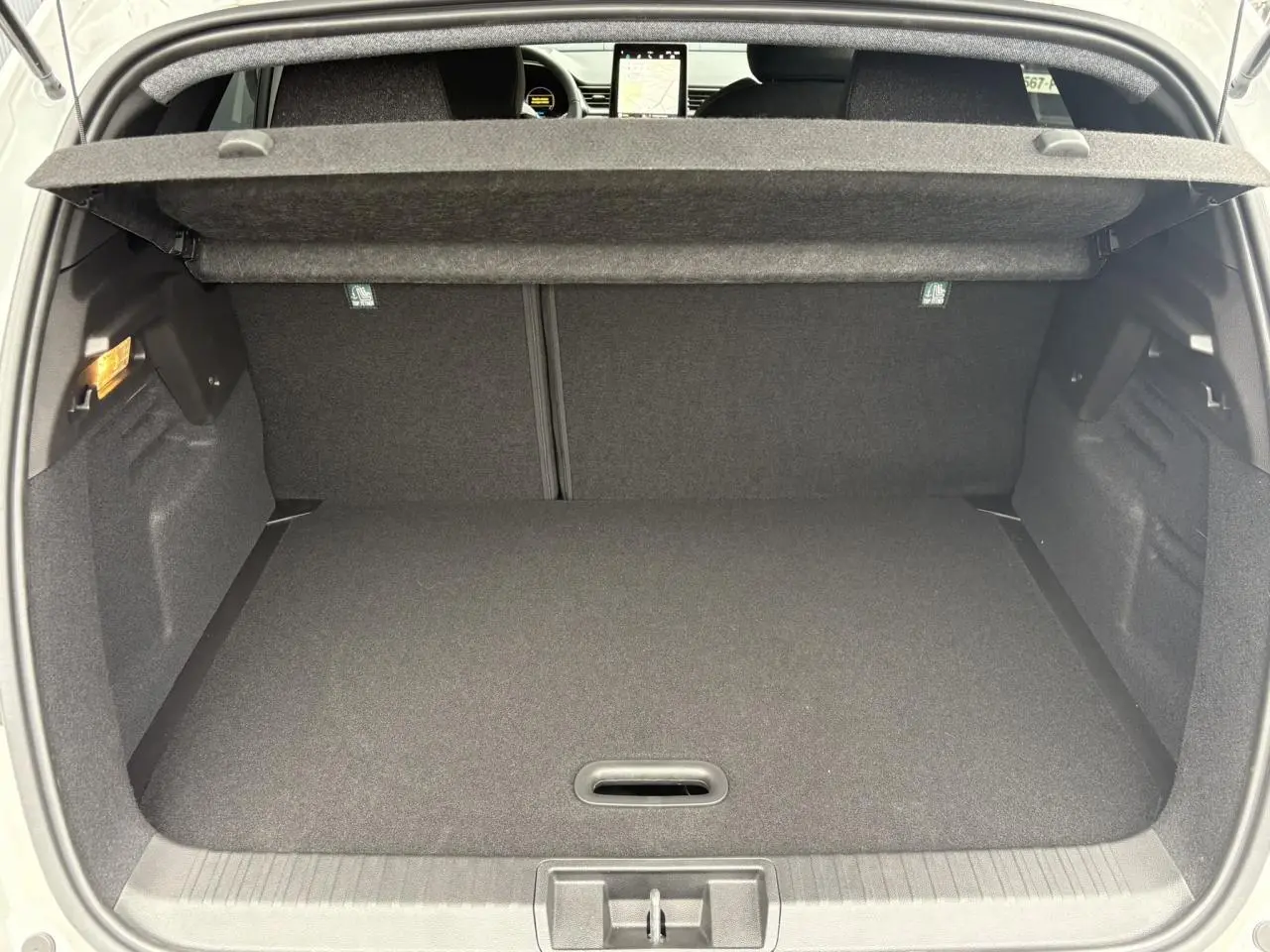 Coffre ouvert du Renault Captur blanc nacré, vue arrière montrant l'espace de rangement et la tablette de couverture.