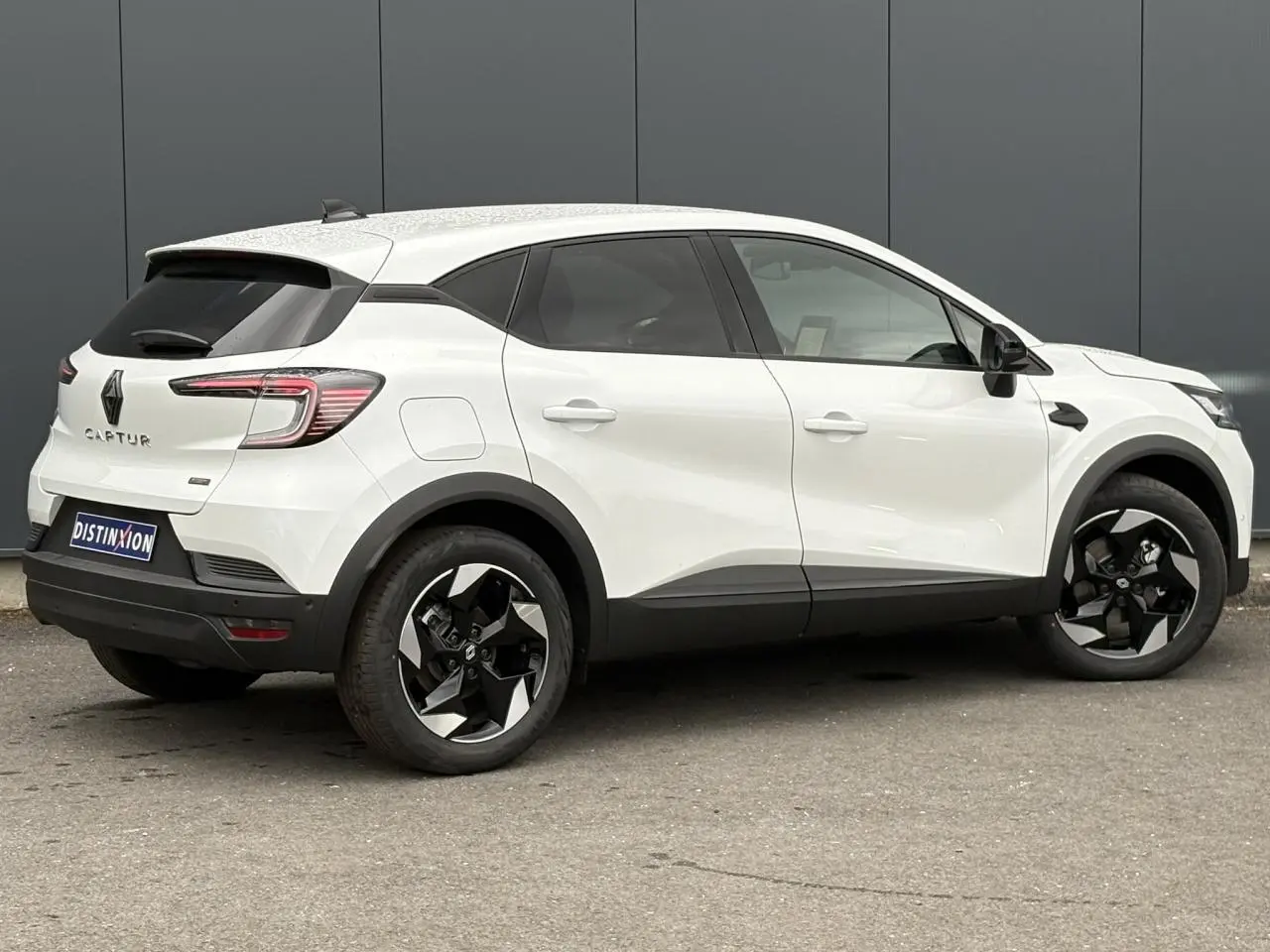 Renault Captur blanc nacré en vue de profil côté droit, avec jantes aluminium 18 pouces et vitres surteintées.