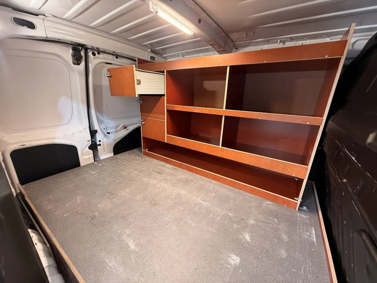 Vue intérieure arrière du Citroën Berlingo blanc 2019, montrant l'espace de chargement avec étagères en bois intégrées.