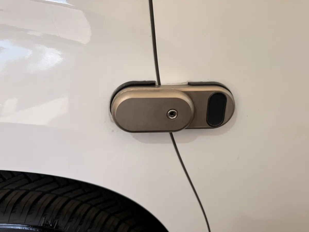 Gros plan sur la serrure métallique de la porte latérale blanche d’un Citroën Berlingo 2019.