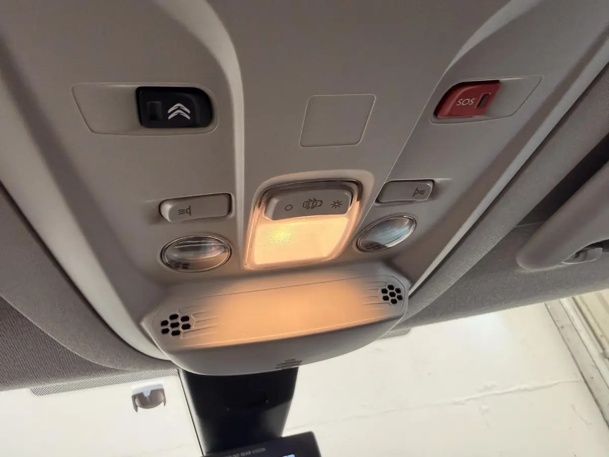 Vue en gros plan du plafonnier intérieur du Citroën Berlingo blanc 2019 avec boutons d’éclairage et alerte SOS.
