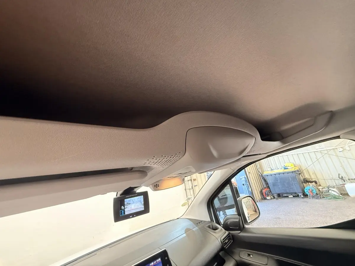 Vue intérieure côté passager du tableau de bord d'un Citroën Berlingo blanc 2019 avec écran de caméra de recul.