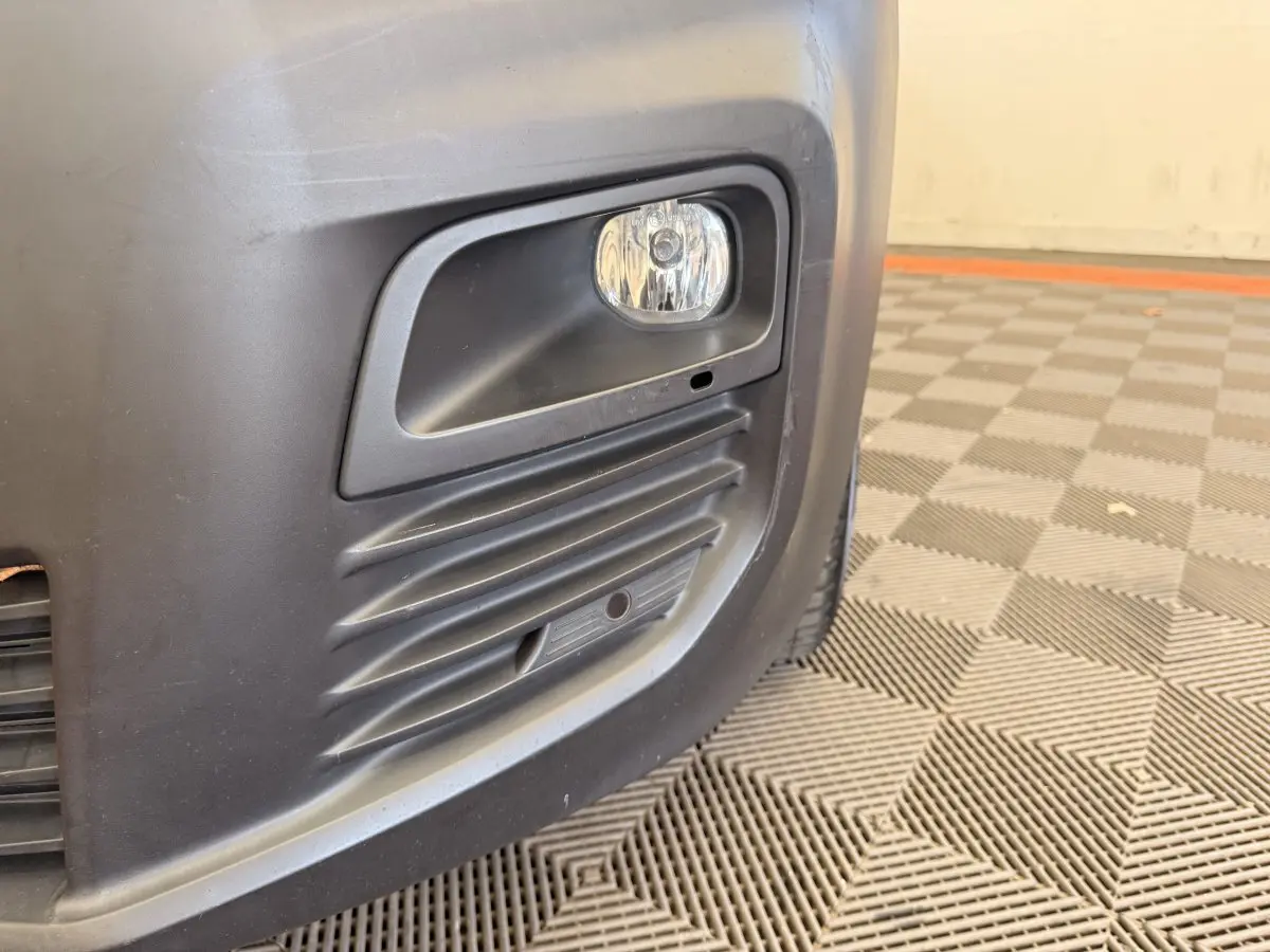 Gros plan sur le feu antibrouillard avant droit du Citroën Berlingo blanc de 2019 avec pare-chocs noir mat.