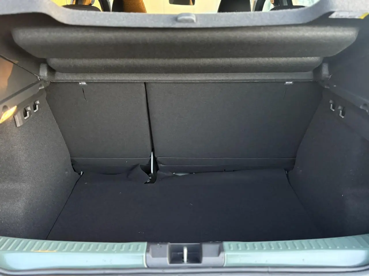 Coffre ouvert d'une Dacia Sandero Stepway 2025 couleur kaki lichen, montrant l'espace de chargement intérieur.