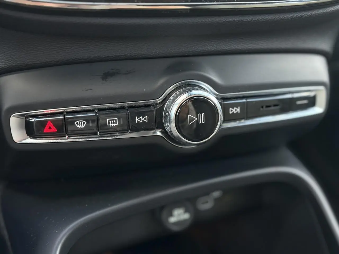 Gros plan sur la commande audio centrale noire et chrome du tableau de bord du Volvo XC40 2024.