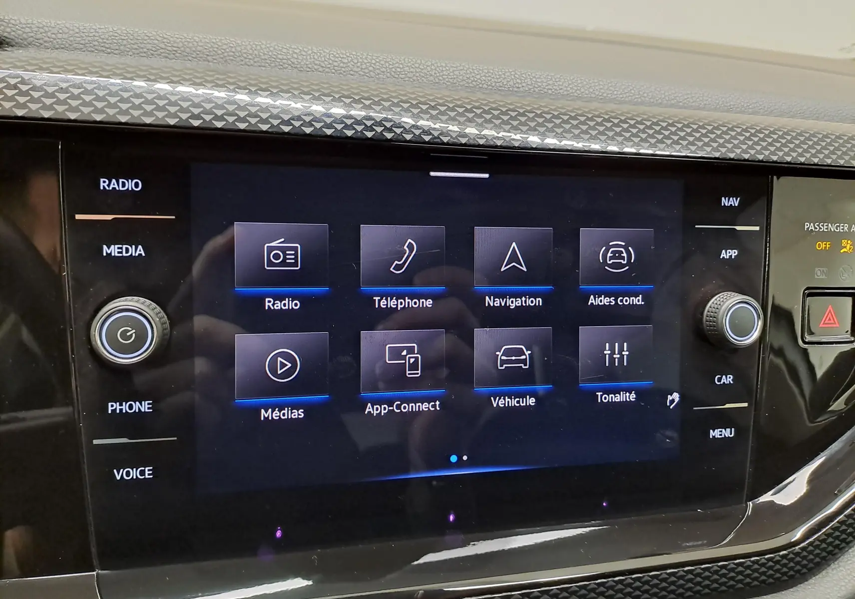 Vue de face du tableau de bord du Volkswagen Taigo 2024, écran tactile central avec menu multimédia affiché.