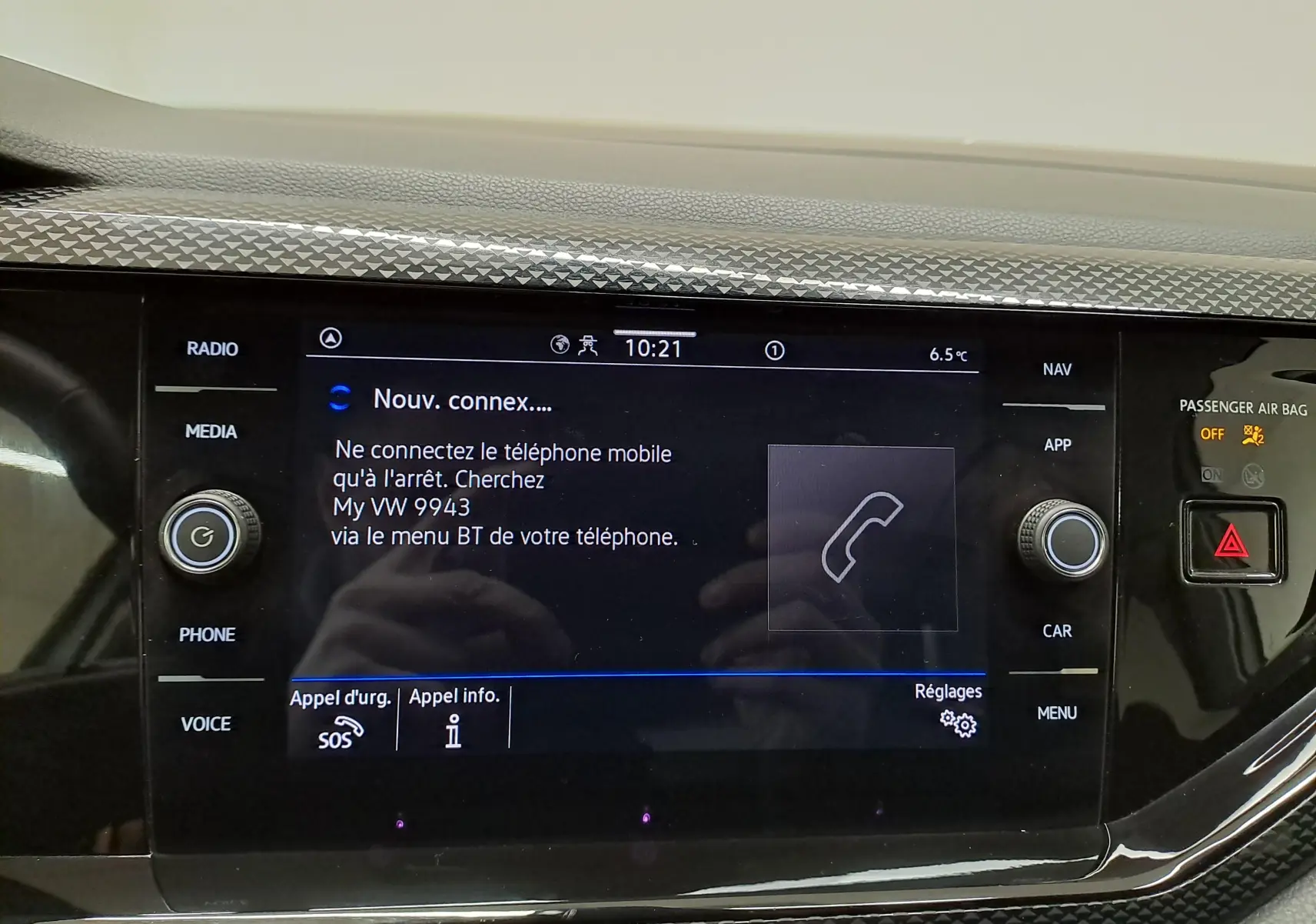 Écran tactile central du tableau de bord du Volkswagen Taigo blanc, affichant la connexion Bluetooth et commandes autour.