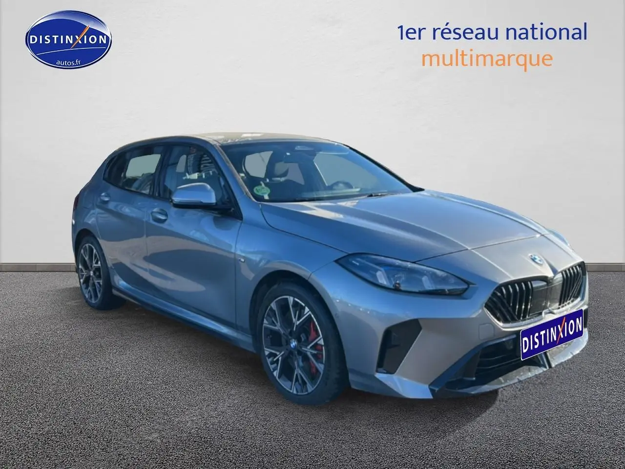 BMW Série 1 118da 2025 gris skyscraper vue 3/4 avant droit avec jantes 18 pouces bicolores et calandre noire.