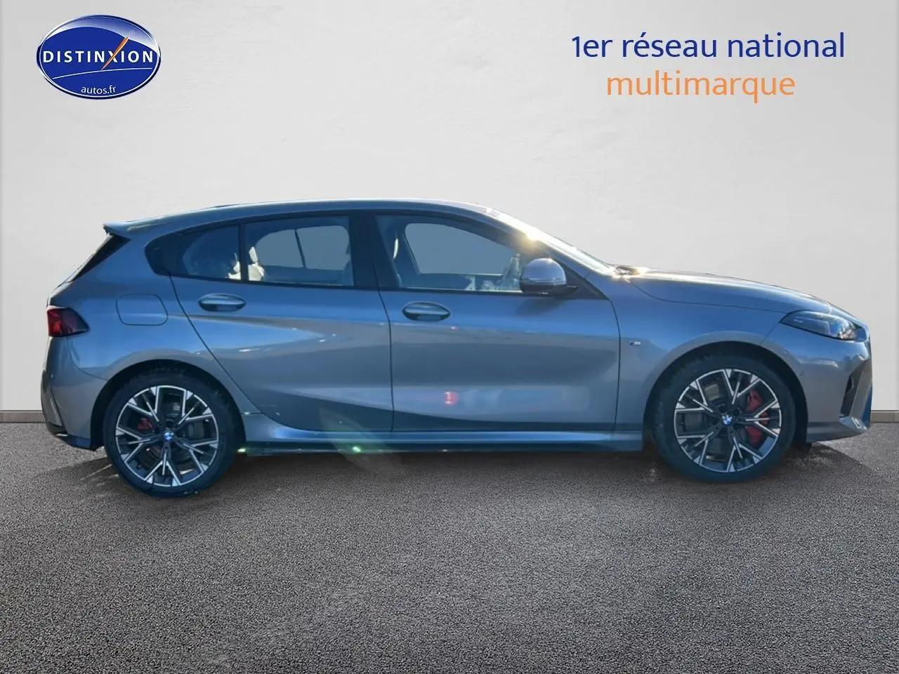 Profil droit d'une BMW Série 1 118da 2025 gris skyscraper avec jantes 18 pouces bicolores et étriers rouges.