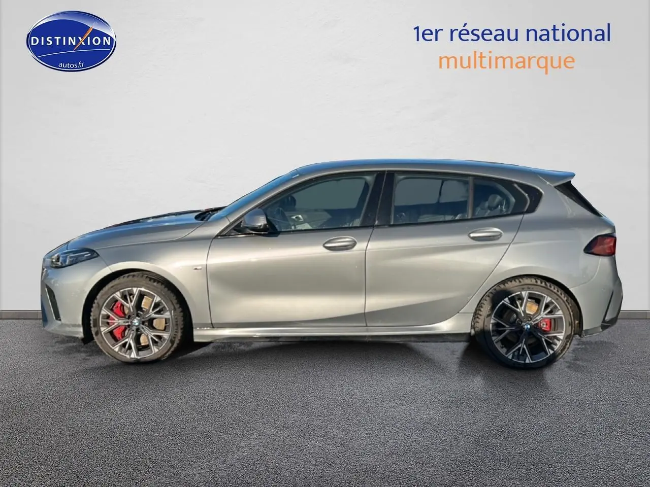 BMW Série 1 118da gris Skyscraper vue de profil côté gauche avec jantes 18 pouces bicolores et étriers rouges.