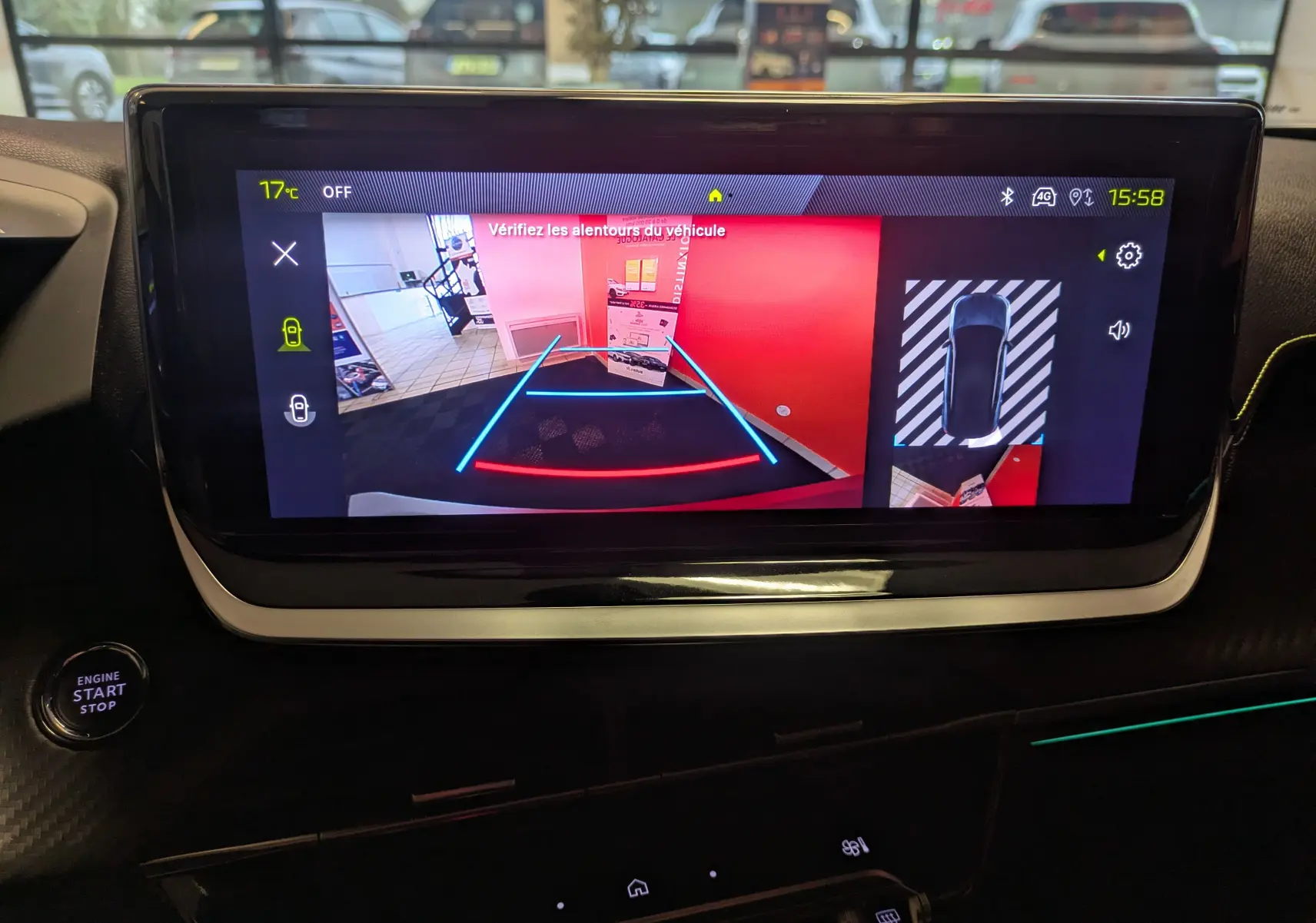 Écran intérieur du Peugeot 2008 Hybrid 145 GT montrant la caméra de recul avec guidage lumineux bleu et rouge.