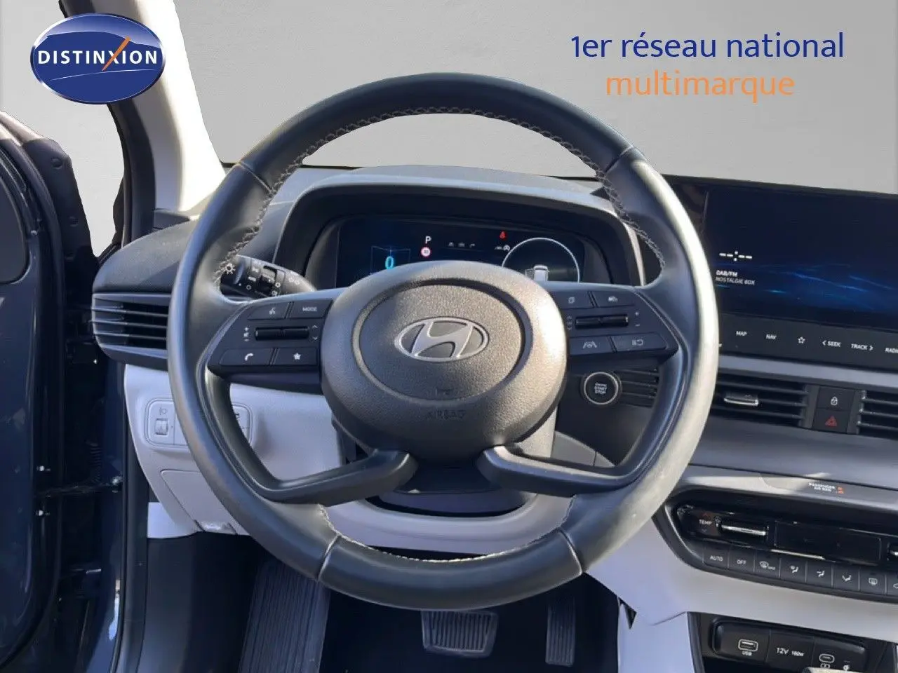 Vue centrée sur le volant cuir de la Hyundai i20 2025 gris Aurora, avec tableau de bord numérique et écran tactile.