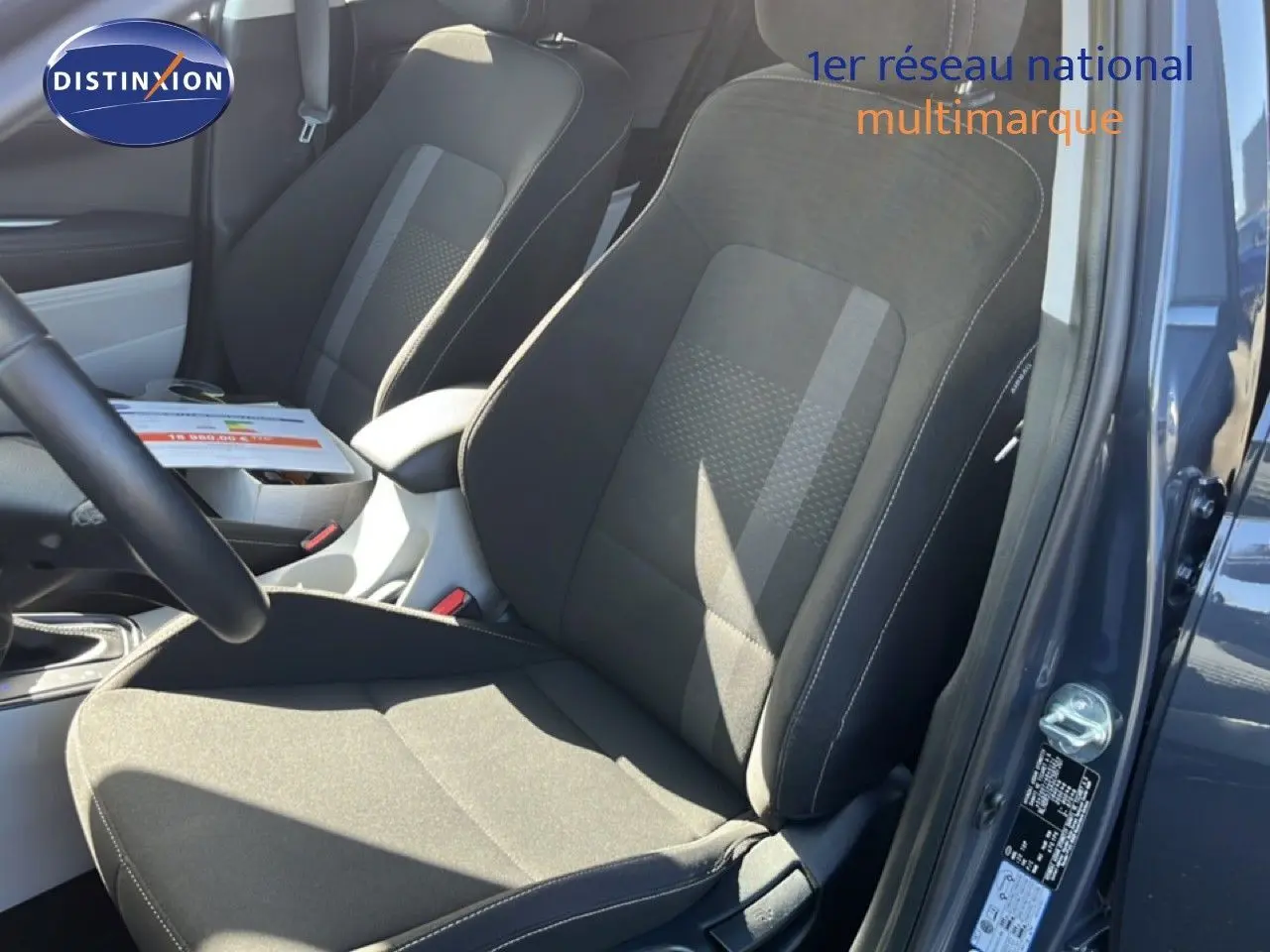 Vue intérieure côté conducteur de la Hyundai i20 2025 gris Aurora, mettant en valeur les sièges tissu noir et console centrale.