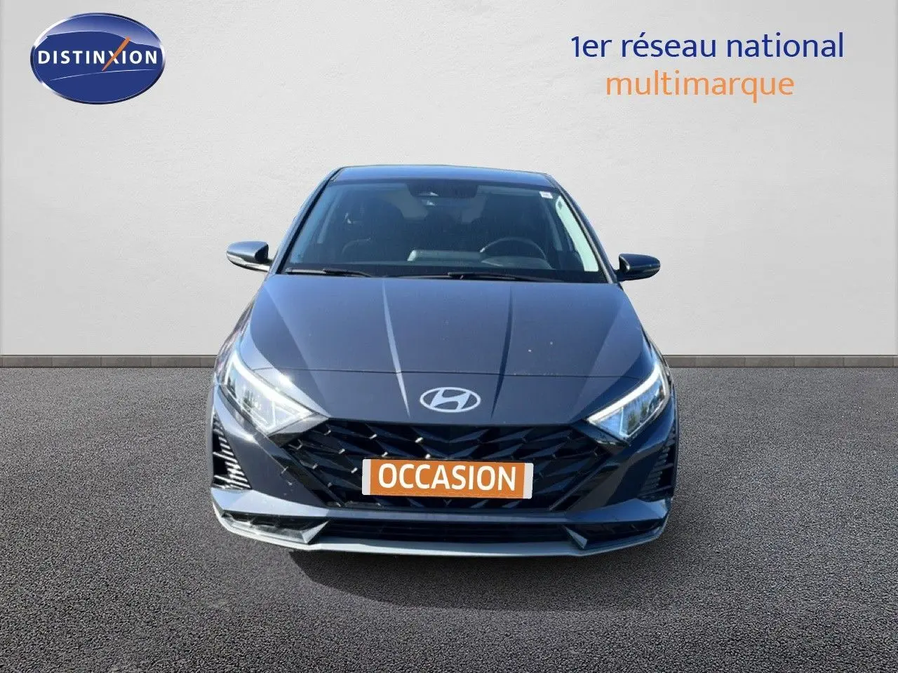 Vue avant d'une Hyundai i20 2025 gris aurora metal avec calandre noire et phares LED allumés.