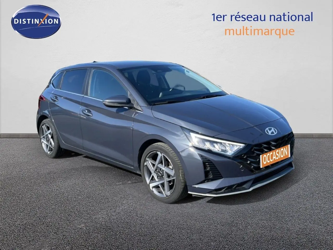 Hyundai i20 gris Aurora métal en 3/4 avant droit, avec jantes alliage et calandre noire distinctive.