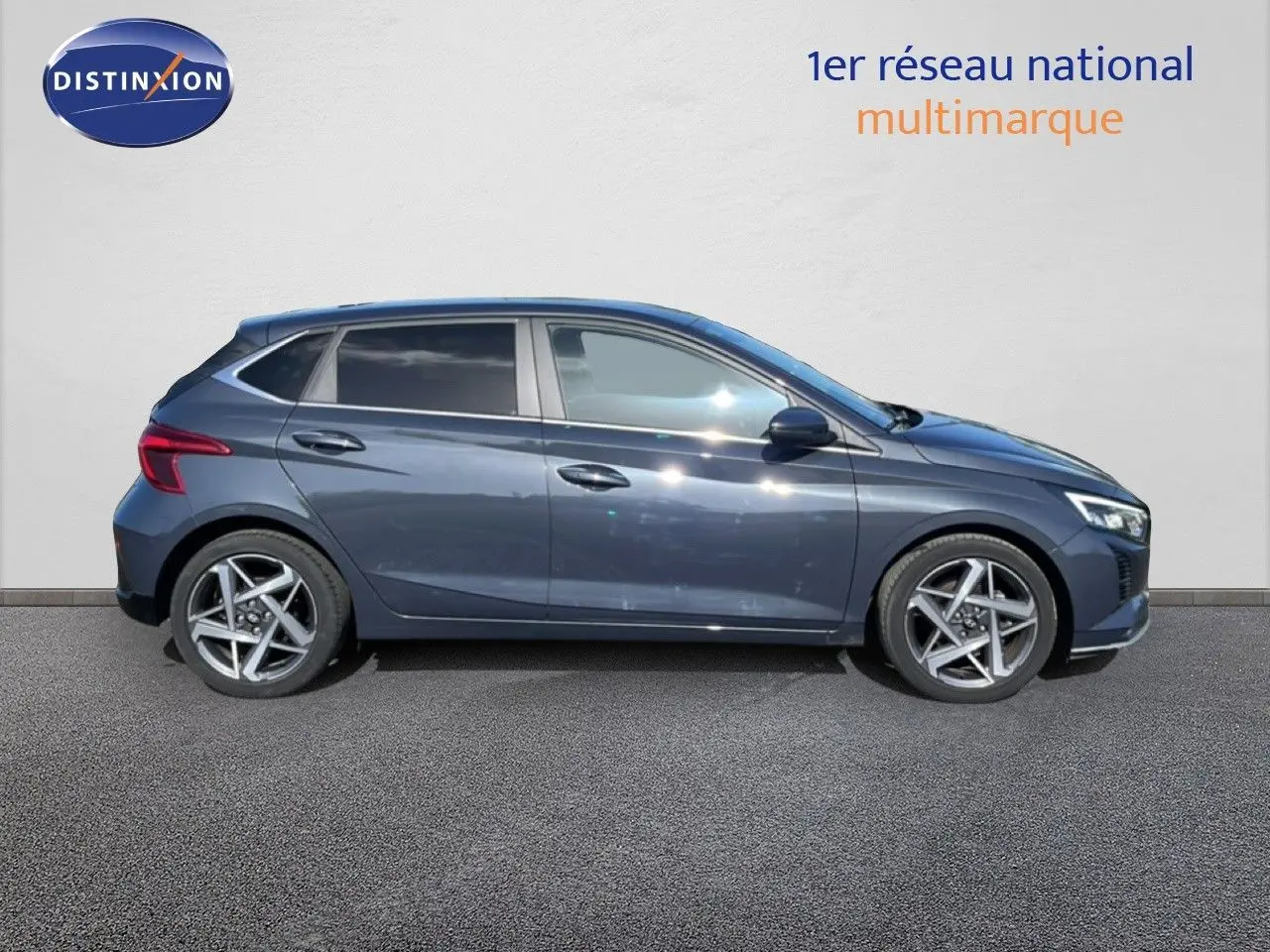 Vue de profil côté gauche d'une Hyundai i20 gris aurora metal avec jantes alliage et vitres teintées.