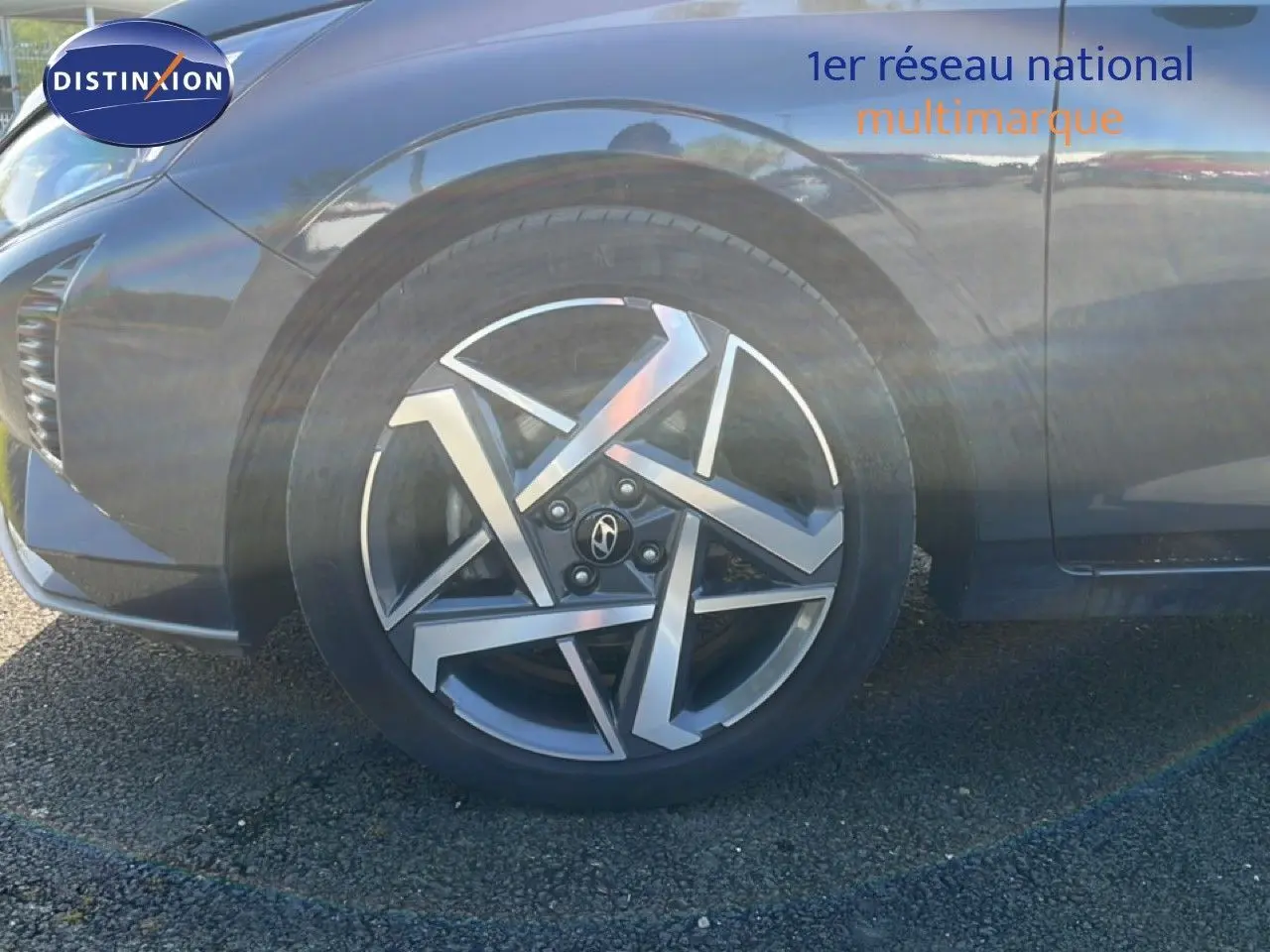 Gros plan sur la roue avant droite d'une Hyundai i20 gris aurora métal avec jante alliage au design géométrique.