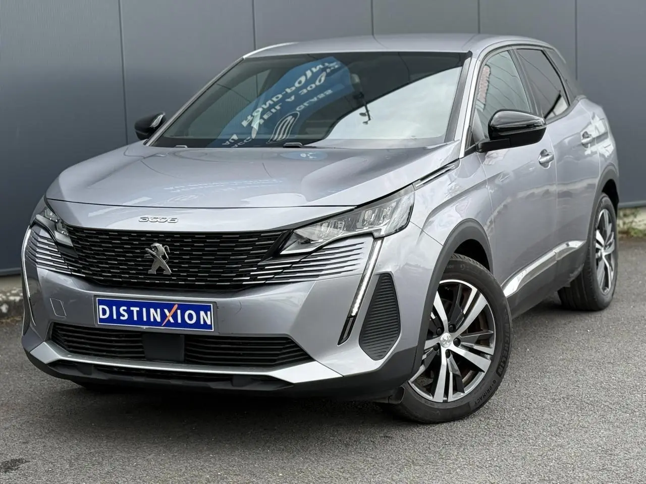Peugeot 3008 gris Artense en 3/4 avant droit, avec jantes alliage bi-ton et calandre noire distinctive.