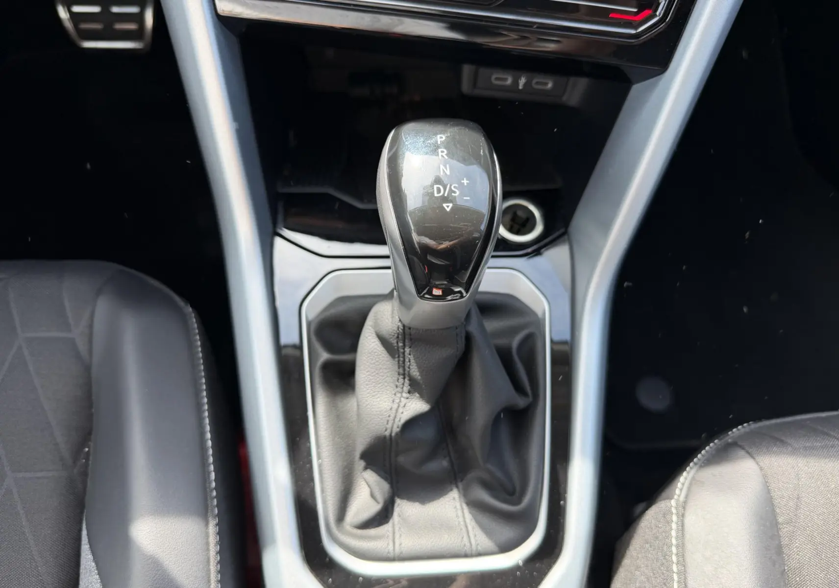 Vue rapprochée du levier de vitesses automatique noir dans l’habitacle du Volkswagen T-Roc gris.