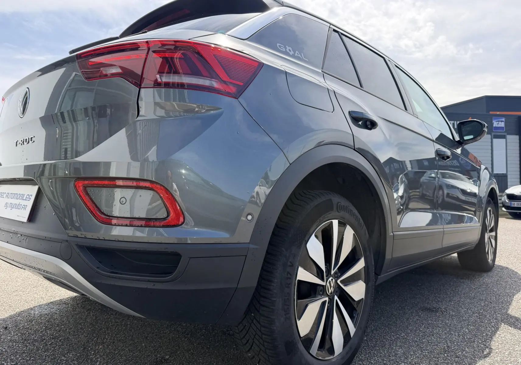 Vue 3/4 arrière droite d’un Volkswagen T-Roc gris avec feux arrière LED et jantes alliage distinctives.