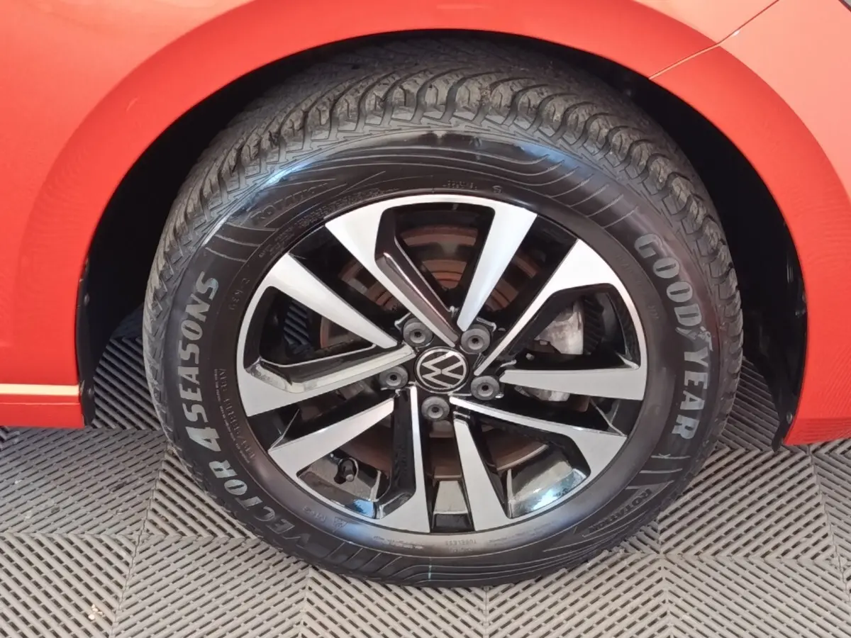 Gros plan sur la roue avant droite d'une Volkswagen Polo orange avec jante alliage bicolore et pneu Goodyear.