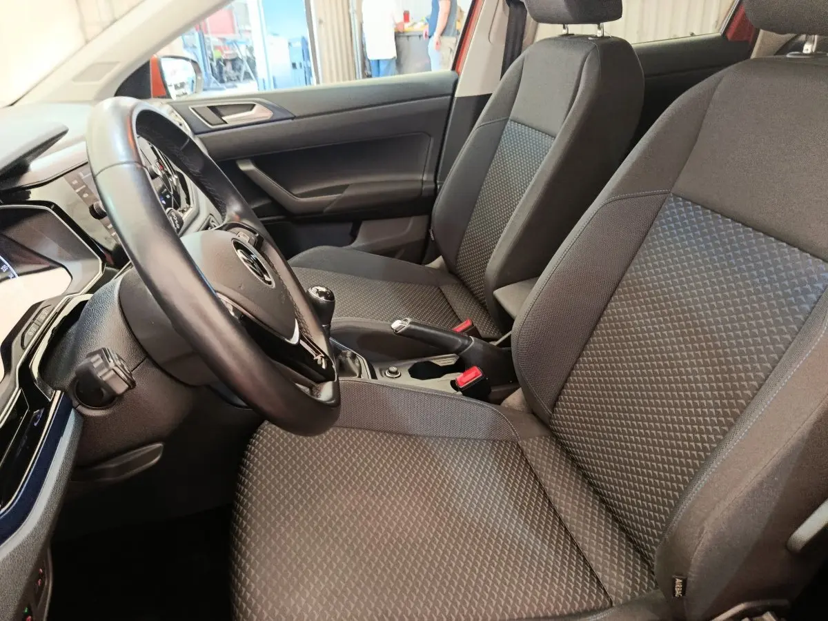 Vue intérieure côté conducteur de la Volkswagen Polo 1.0 TSI 95 United avec sièges tissu gris et volant cuir multifonctions.