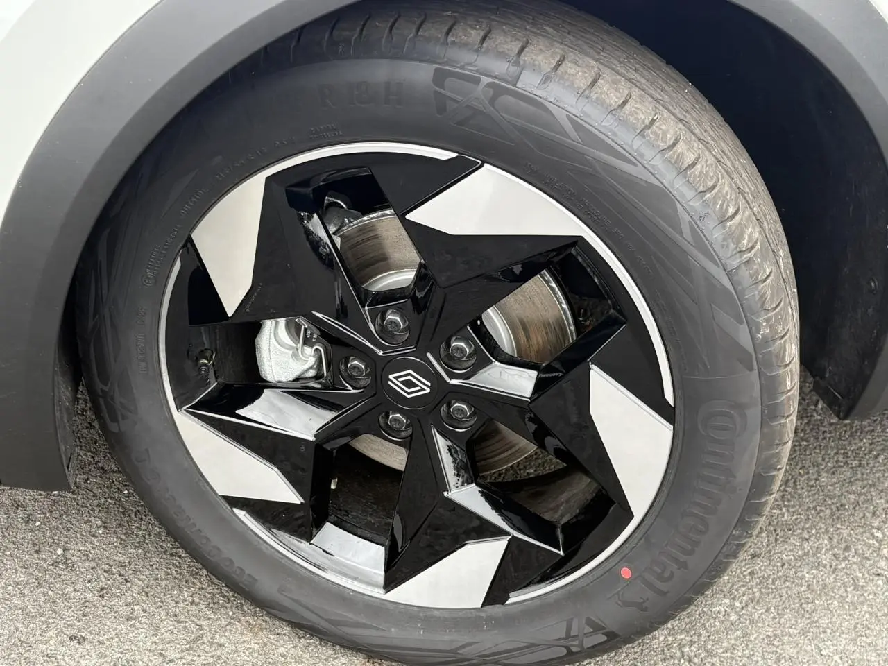 Gros plan sur la jante aluminium 18 pouces Black Hole noire et argentée du Renault Captur blanc nacré.