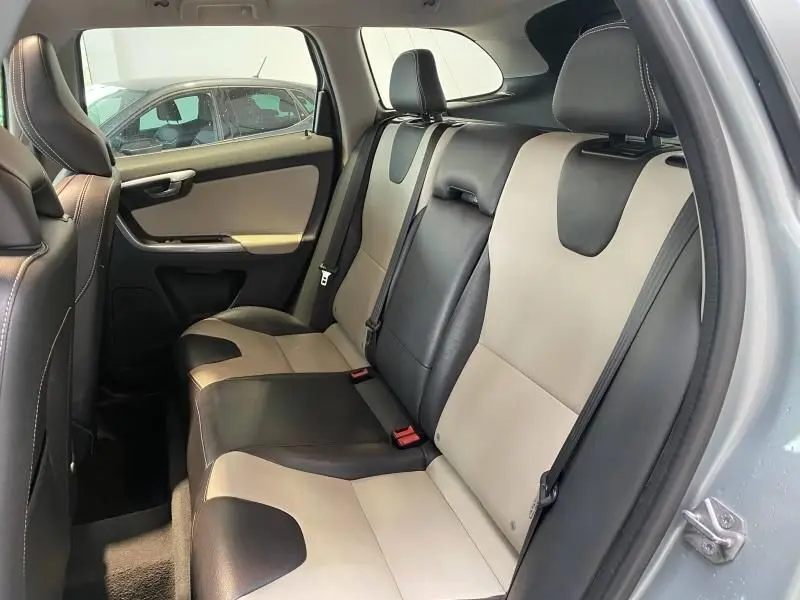 Vue côté gauche de la banquette arrière bicolore noire et beige du Volvo XC60 argenté de 2015.
