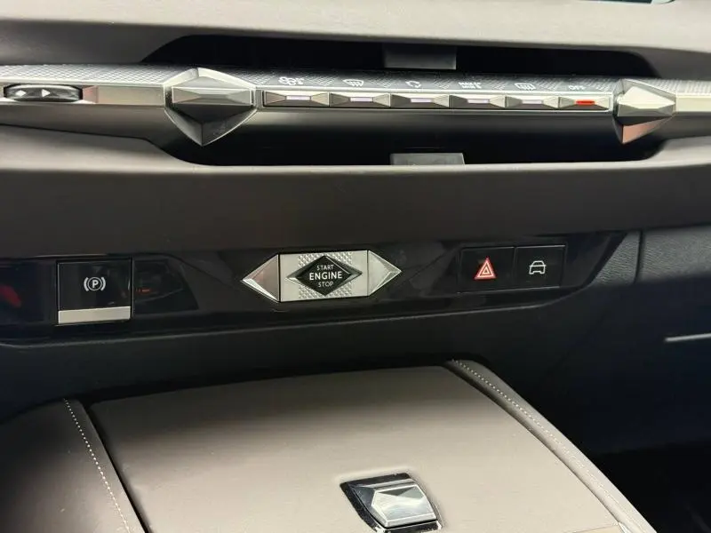 Détail du tableau de bord du DS4 2023 Gris Platinium, avec bouton start/stop central et commandes de sécurité visibles.