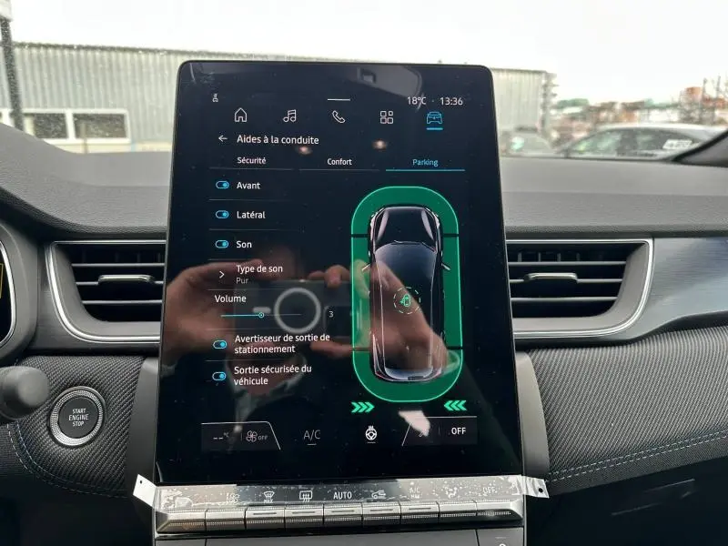 Vue intérieure du tableau de bord du Renault Captur 2026, écran tactile affichant les aides à la conduite en mode parking.