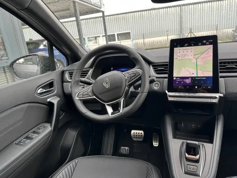 Vue intérieure côté conducteur du Renault Captur 2026 hybride, avec volant multifonction et écran tactile vertical.